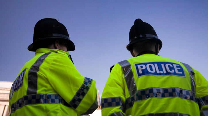 Two British Policemen wearing Traditional Helmets